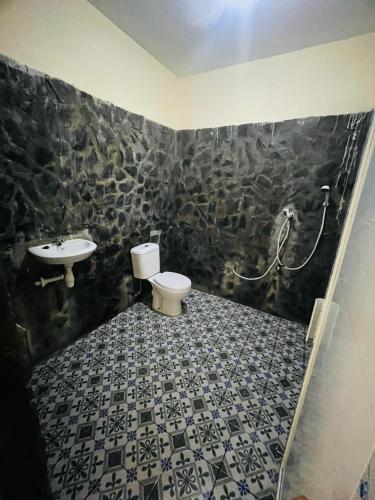 a bathroom with a toilet and a sink at Mawar Bungalow in Gili Trawangan