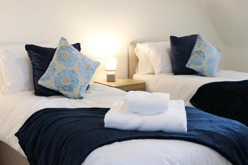 two beds with towels on top of them in a room at Modern 3-Bedroom - VAT Included - Private Drive Parking in Stafford