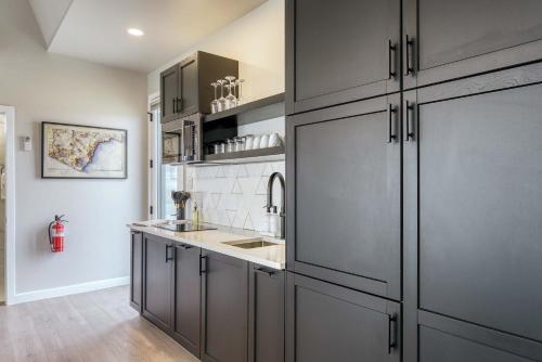 a kitchen with gray cabinets and a sink at Stardust Big Bend Luxury A-Frame#2 with a fab view in Terlingua