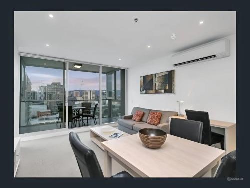 a living room with a couch and a table with chairs at Swainson on Balfours in Adelaide