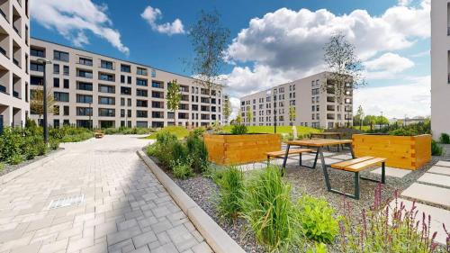 a courtyard with a table and benches and buildings at Apartmán Galileo in Trnava