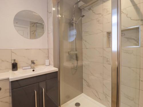 a bathroom with a shower and a sink at Ted's Cottage in Skipton