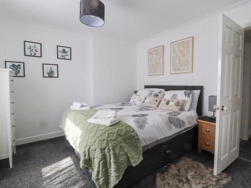 a bedroom with a bed with white walls at Ted's Cottage in Skipton