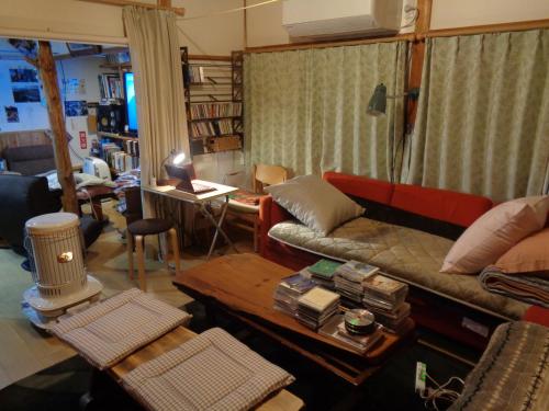 a living room with a couch and a table at Premium Guest House Alaskan Dream in Akiota