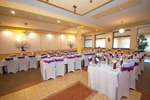 a banquet hall with white tables and purple chairs at Penzión ZIVKA in Závažná Poruba