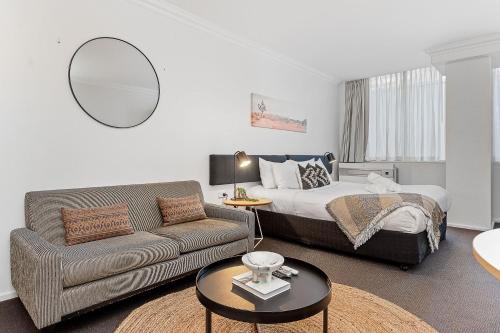 a living room with a bed and a couch at Central City Living Murray Street Studio in Perth