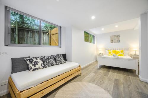 a living room with a couch and a window at Collaroy 3Br Beach Home with Large Pool Ground Floor in Collaroy