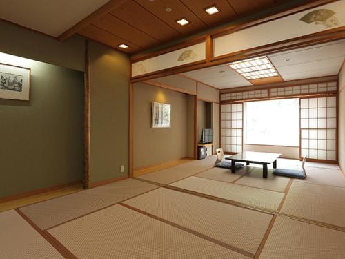 a living room with a table and a window at Nishiizu Crystal View Hotel in Nishiizu