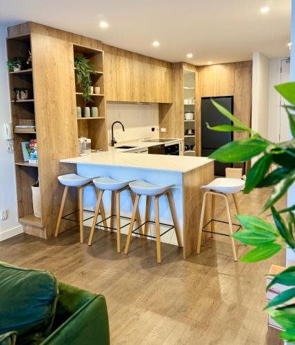 a kitchen with a large island with bar stools at Beach Front Dream Lifestyle in Auckland