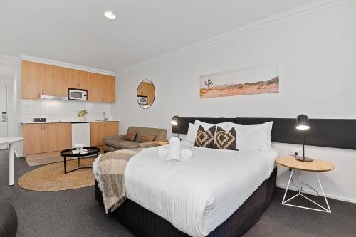 a bedroom with a large bed and a living room at Best Location Downtown Perth in Perth