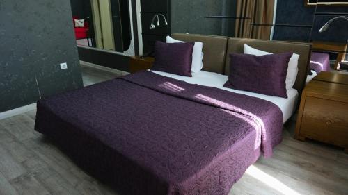 a bedroom with a purple bed with purple sheets and pillows at ATAKUM PALAS OTEL in Samsun