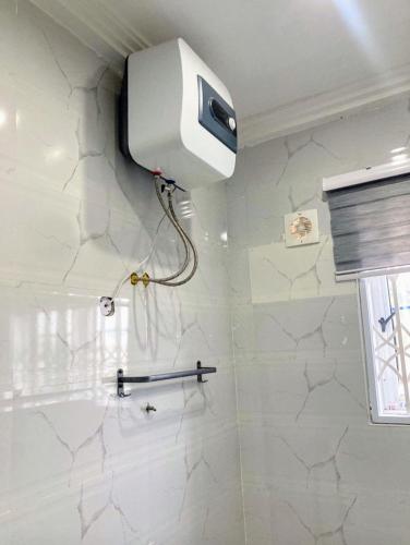 a blow dryer on the wall of a bathroom at Sugarville, Swimming pool with a Rooftop in Accra