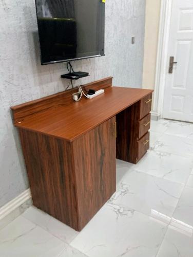 a wooden desk with a television on top of it at Sugarville, Swimming pool with a Rooftop in Accra