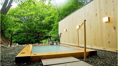 a swimming pool in front of a wooden wall at Mogamitakayu Zenshichinoyu Ohira in Zao Onsen