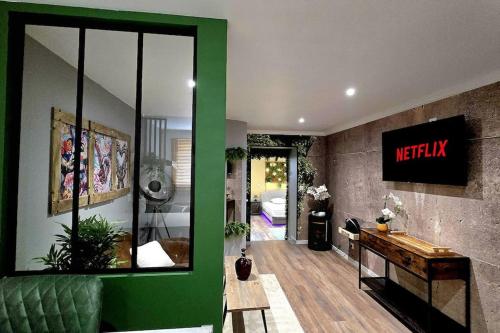 - un salon avec un mur vert et un signe ametiki dans l'établissement Loft Suite de luxe - Jacuzzi - SPA - Balnéo Vendôme, à Vendôme