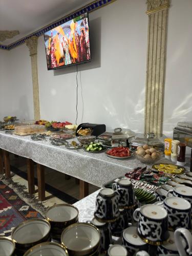a table with a bunch of plates and cups at Bukhara Zaringiz PREMIUM in Bukhara
