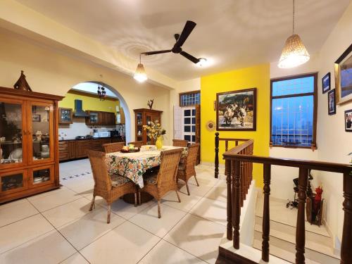 a kitchen and dining room with a table and chairs at Rashmi Cottage - 4 BHK Villa with Serene Valley Views in Dagshai
