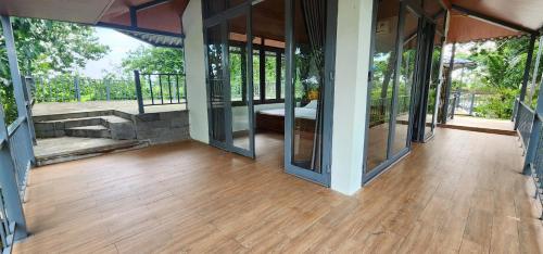 an empty house with glass doors and a wooden floor at An Nhien Garden in Long Khanh