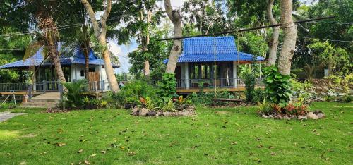 a house with a blue roof in a yard at An Nhien Garden in Long Khanh