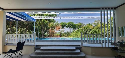 a house with a swimming pool and two chairs at An Nhien Garden in Long Khanh