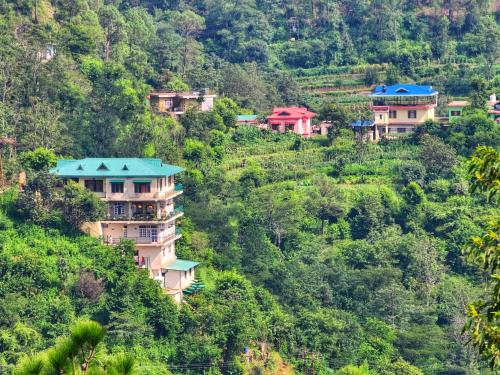 a group of houses on the side of a mountain at Rashmi Cottage - 4 BHK Villa with Serene Valley Views in Dagshai