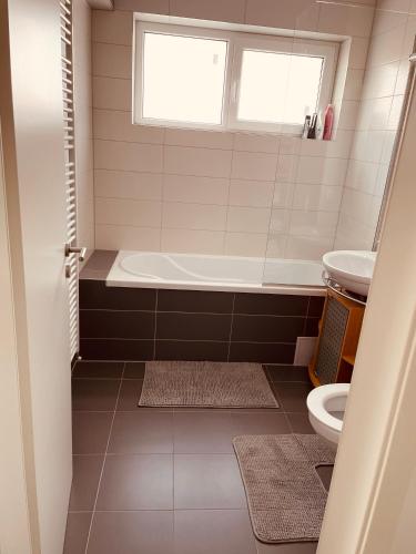 a bathroom with a tub and a toilet at Leon's home in Şelimbăr