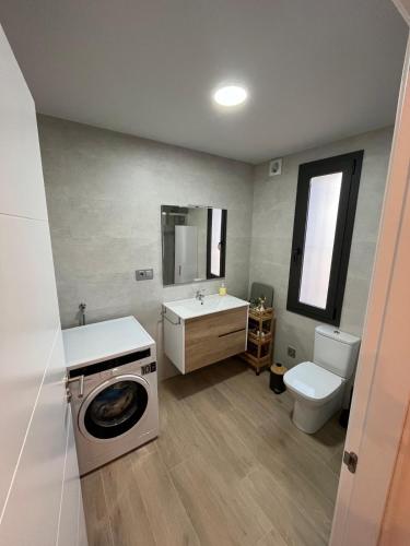 a bathroom with a washing machine and a toilet at Ca l'Artigalas in Cardona