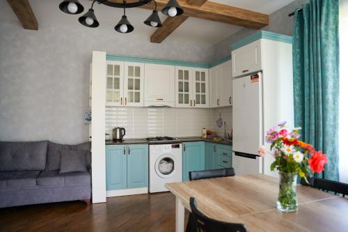 a kitchen with blue cabinets and a table with flowers at Abbasov's guest house-In Lahij in Lahıc