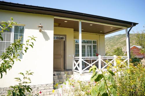 a front porch of a house with a white fence at Abbasov's guest house-In Lahij in Lahıc
