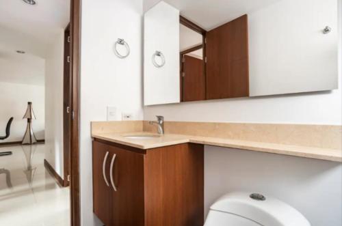 a bathroom with a sink and a toilet and a mirror at Lujoso y Economico Apartamento in Envigado