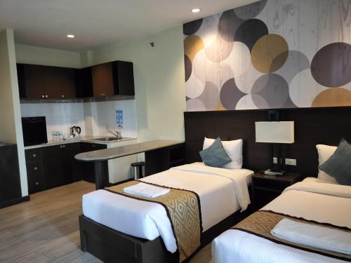 a hotel room with two beds and a kitchen at Whitewoods Convention and Leisure Hotel by SMS Hospitality in Silang