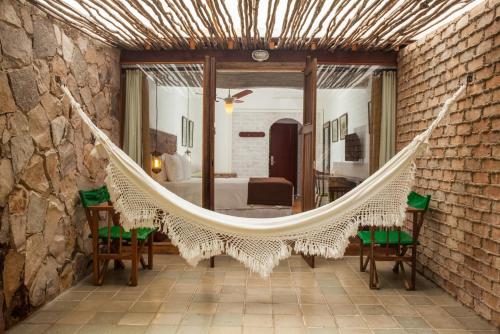 a hammock in a room with a bedroom at Hotel de Lençois in Lençóis