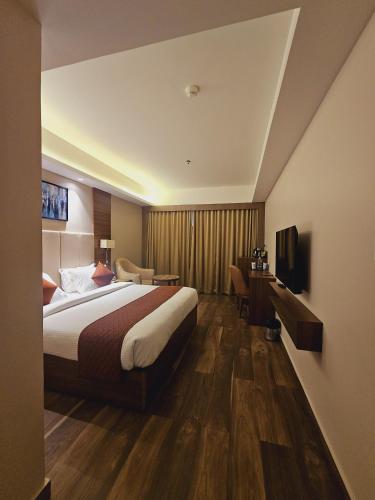 a hotel room with a bed and a television at Utham Mahal in Anchal