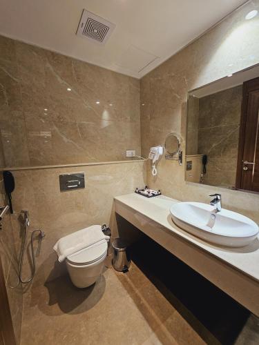a bathroom with a toilet and a sink at Utham Mahal in Anchal