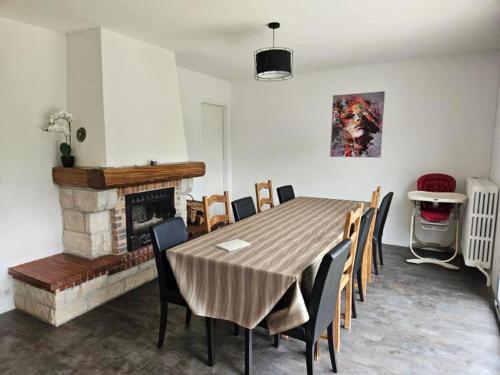 une salle à manger avec une table et des chaises et une cheminée dans l'établissement Maison de campagne en Champagne, à Coupéville