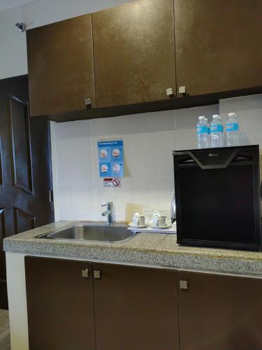 a kitchen counter with a sink and a microwave at Whitewoods Convention and Leisure Hotel by SMS Hospitality in Silang