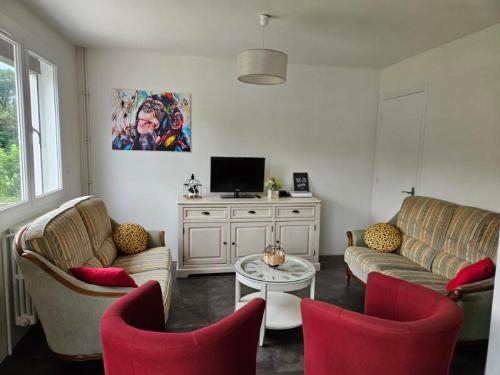 un salon avec deux canapés et une télévision dans l'établissement Maison de campagne en Champagne, à Coupéville