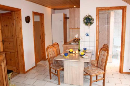 a kitchen with a table and chairs in a room at Hof Reckermann I in Linden