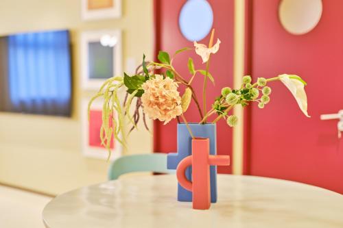 a table with a vase with flowers on it at 寅ホテル 御徒町 TORA HOTEL Okachimachi in Tokyo