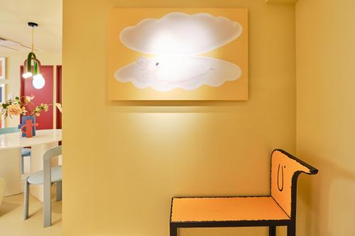 a room with a chair and a cloud light on the wall at 寅ホテル 御徒町 TORA HOTEL Okachimachi in Tokyo
