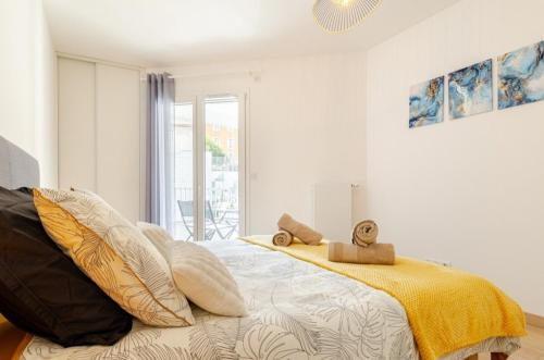 - une chambre avec un lit doté d'oreillers jaunes et blancs dans l'établissement Le paradis au bord du lac, à Annecy