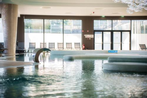 a swimming pool in a building with water in it at HABAKUK Wellness & Event Hotel in Maribor