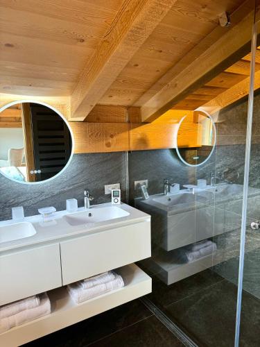 une salle de bain avec deux lavabos et un miroir dans l'établissement Chalet du Feug, à Combloux