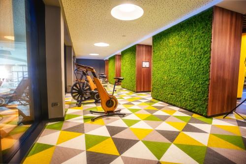 a lobby with a green wall and a treadmill at HABAKUK Wellness & Event Hotel in Maribor