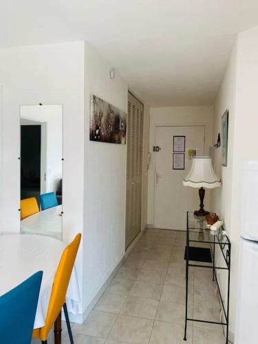 - un salon avec une table, des chaises et une lampe dans l'établissement Superbe appartement à 50m de la mer, balcon vue mer, 2 chambres, à Cavalaire-sur-Mer