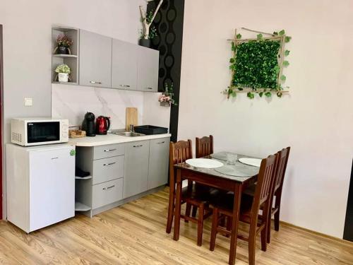 a kitchen with a table and chairs and a microwave at Апартамент Горски кът in Lukovit