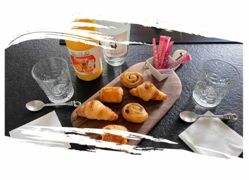 een tafel met een bord donuts op een snijplank bij Chez les Stephs in Magny-le-Hongre