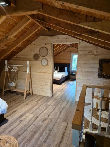 a large room with a bed and a room with wooden floors at Forest Villa, Kaatsheuvel in Loon op Zand