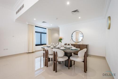a dining room with a table and chairs and a mirror at Deal of the Week 4BR with Pool, Sea & Mountain Views by Deluxe Holiday Homes in Sharm