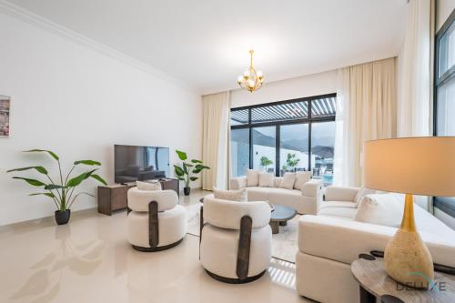a living room with white furniture and a large window at Deal of the Week 4BR with Pool, Sea & Mountain Views by Deluxe Holiday Homes in Sharm